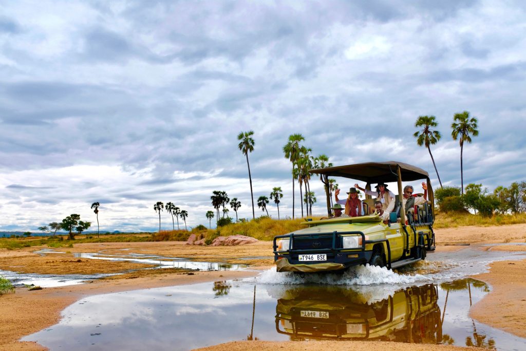 The Pinto family driving through a puddle in a car