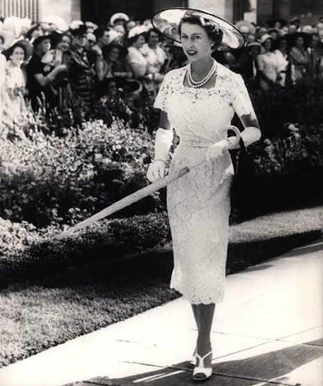 Black and white photo of Queen Elizabeth II holding an umbrella
