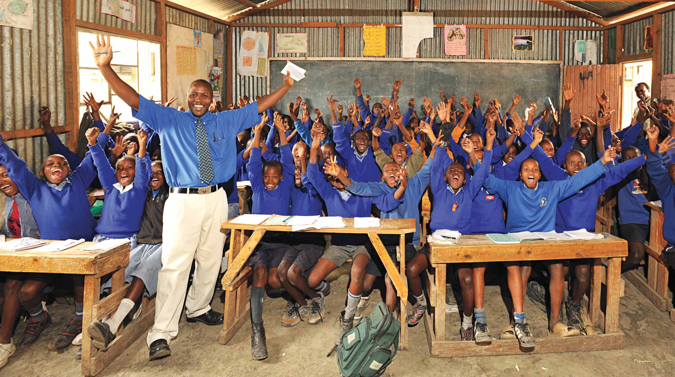 A group of students and a teacher in an AmericaShare classroom happy