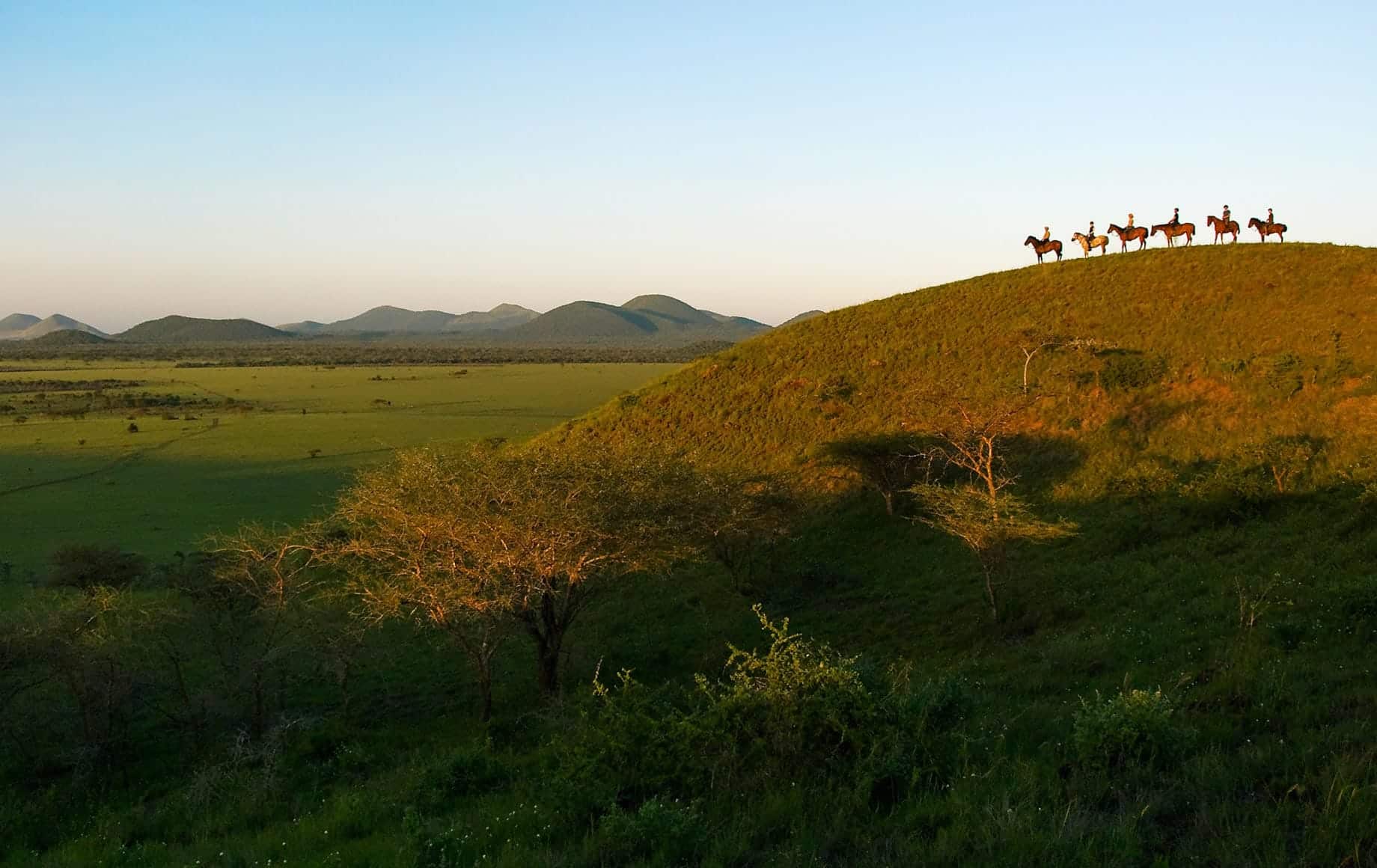 Horseback riding in the wild on a hill at Chyulu Hills