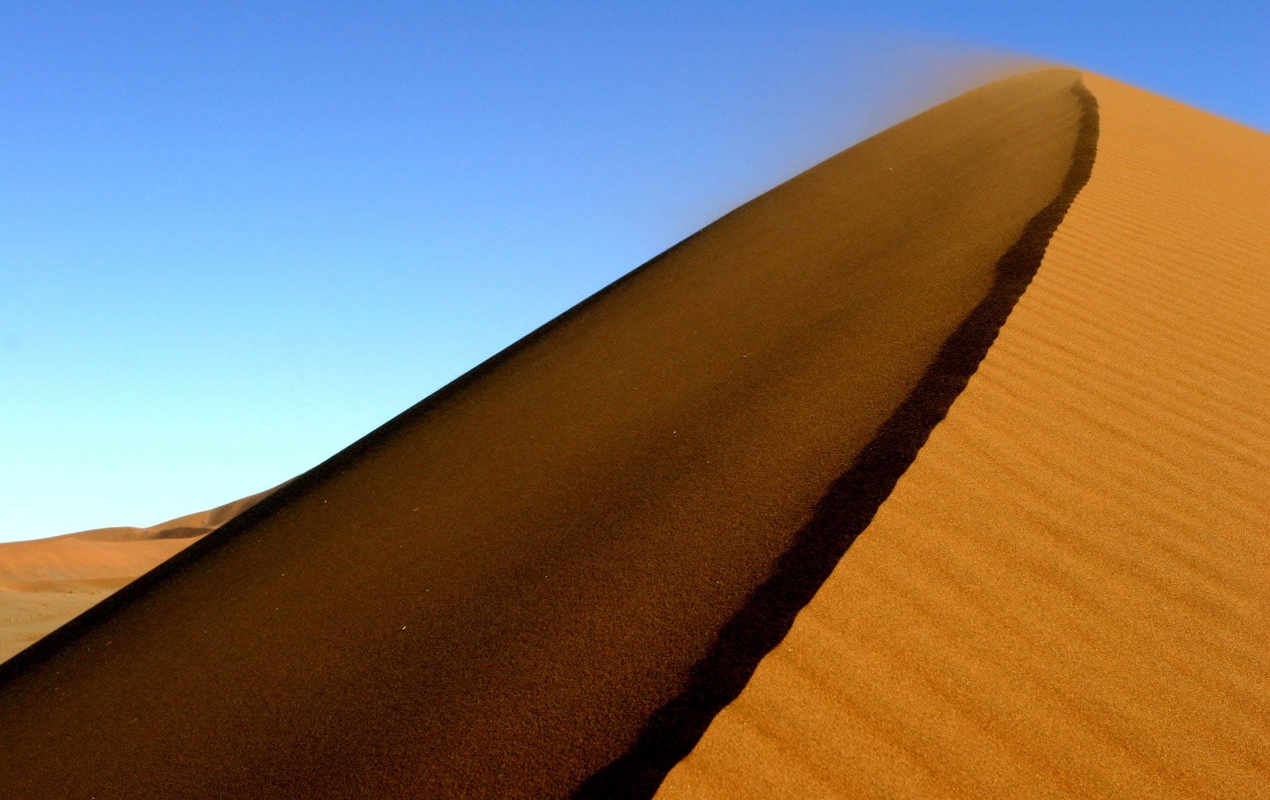 Sand blowing away with the wind at Sossusvlei Namib Desert
