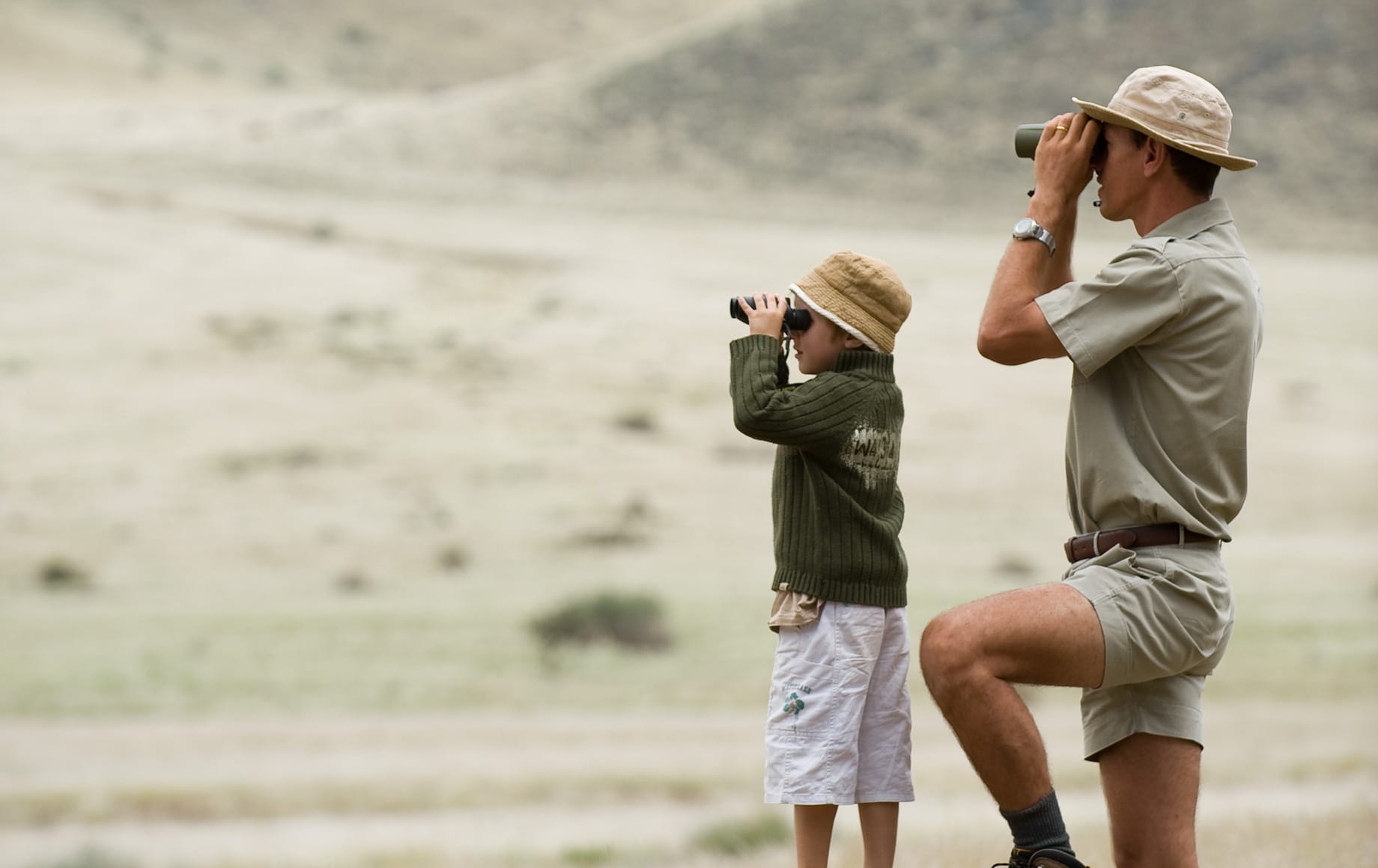 Boy and Man looking out using telescope at Sossusvlei Namib Desert