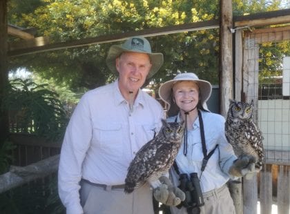 A man and a woman holding owls