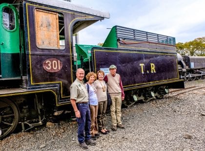 Friends posing for a photo in front of a train