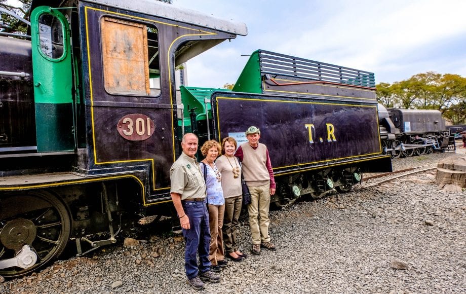 Friends posing for a photo in front of a train