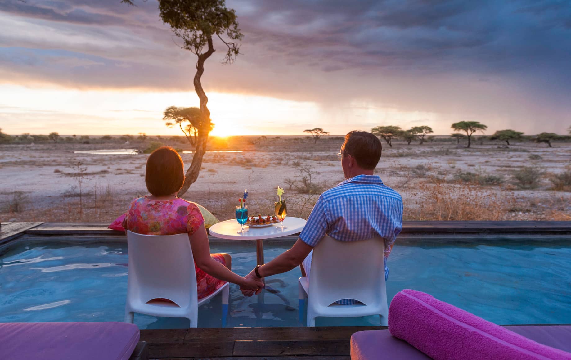 Couple sits at table in African evening