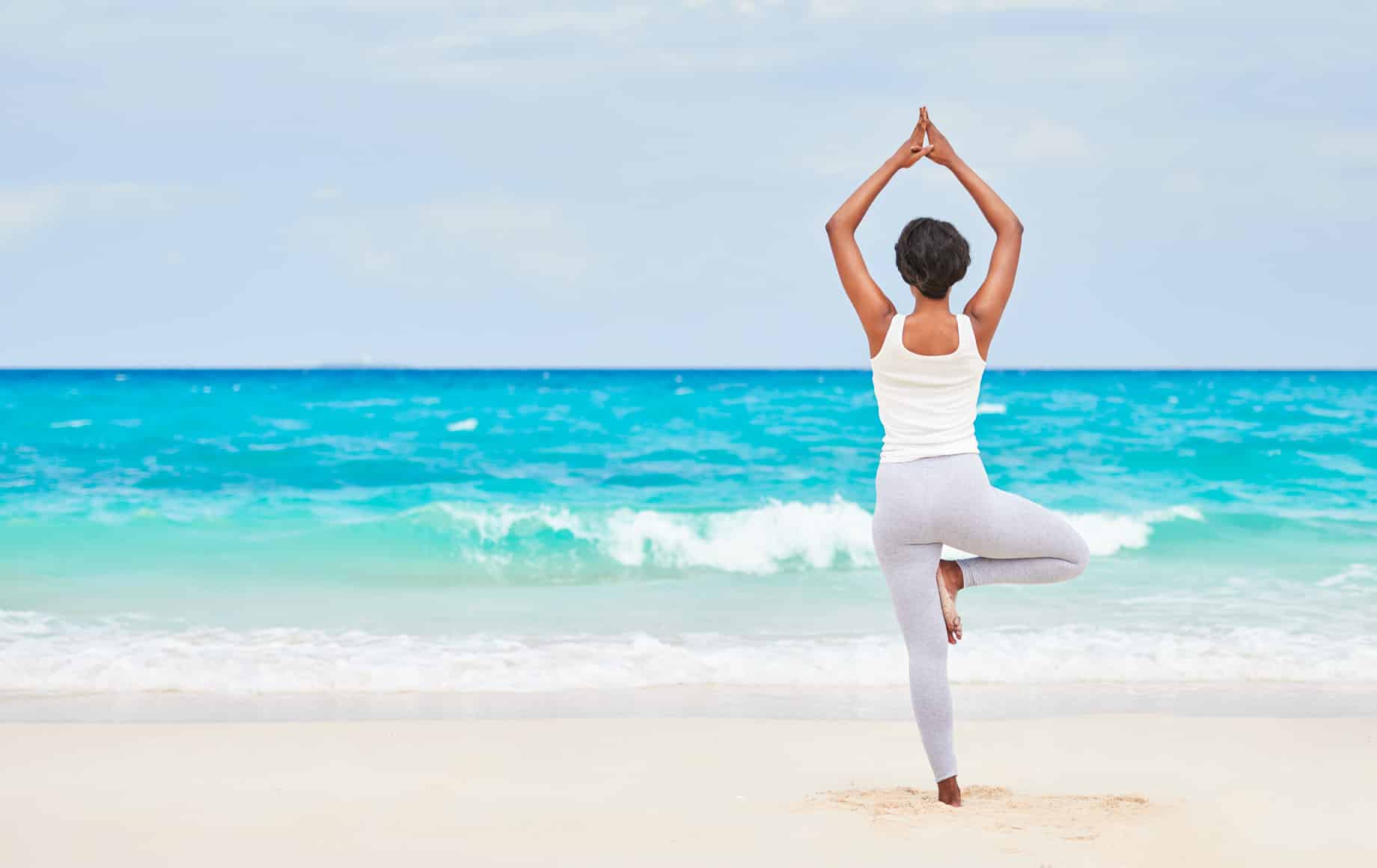 Woman does yoga on beach