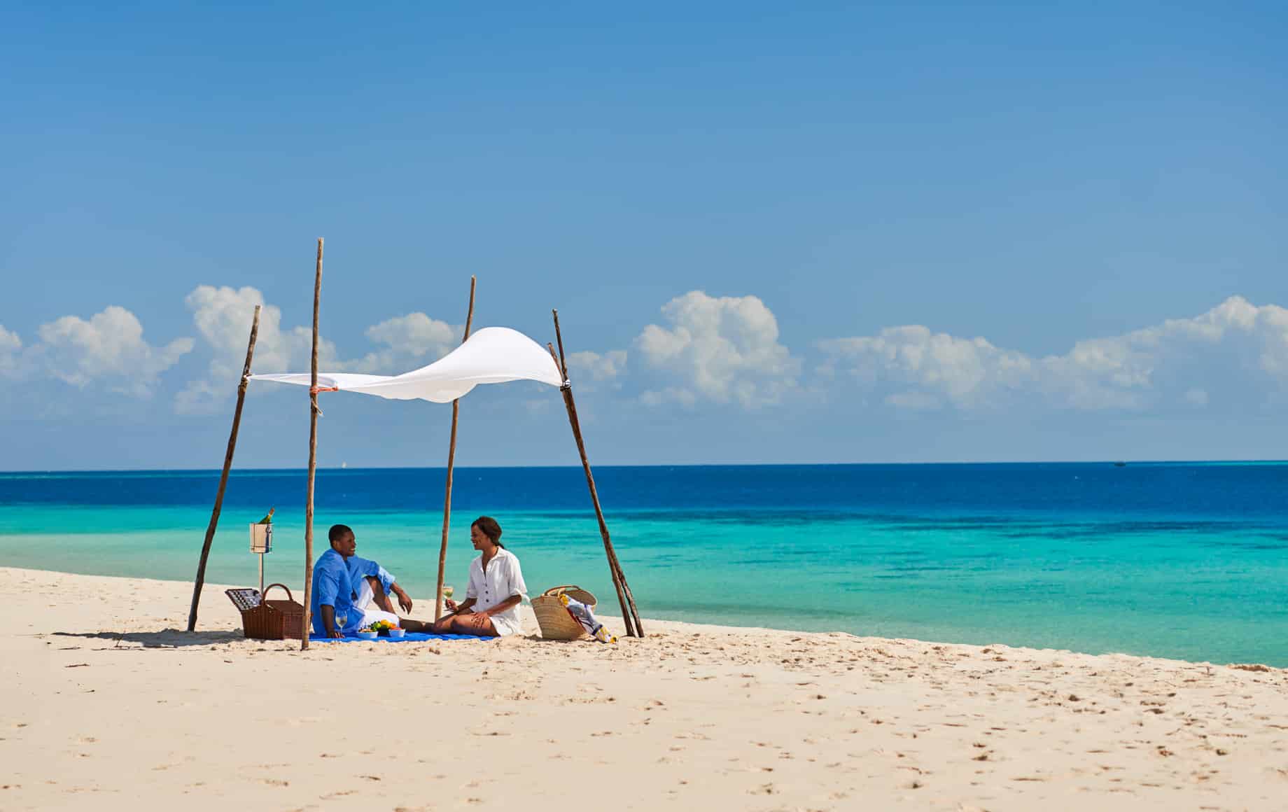 Couple picnics on beach near Park Hyatt, Zanzibar