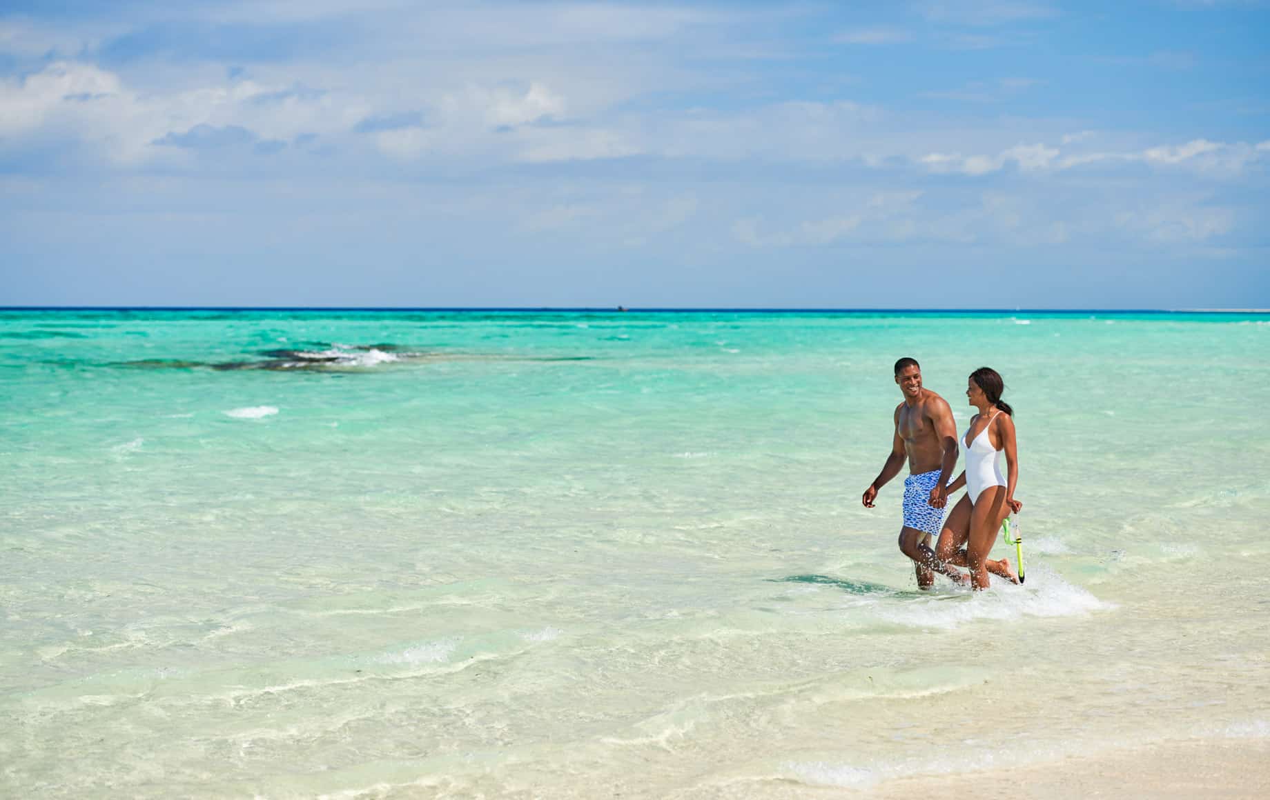 Couple walks along beach near Park Hyatt, Zanzibar