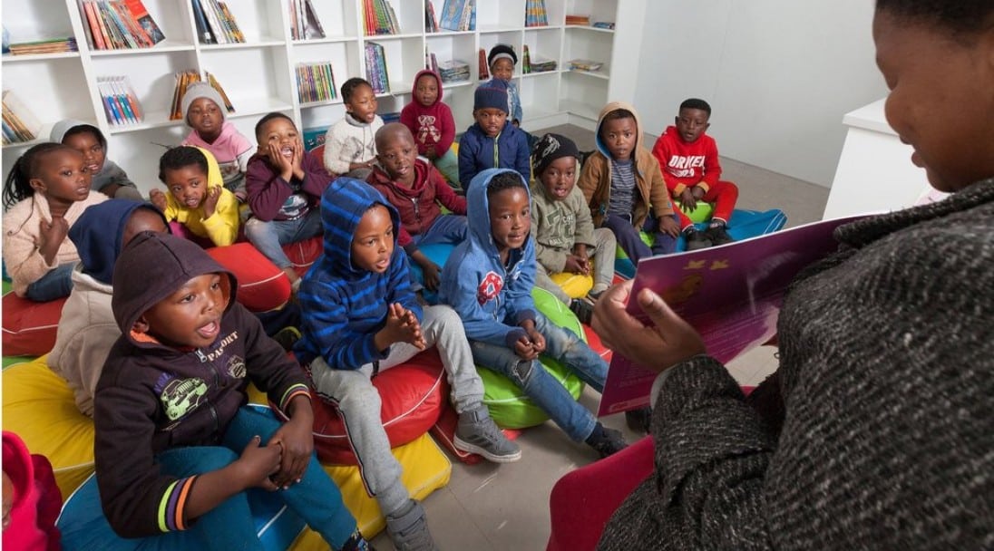 Children happily sitting in a library