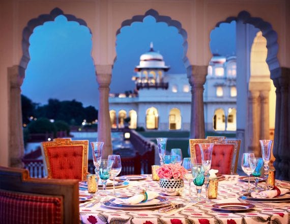 A dinner table set overlooking a palace.