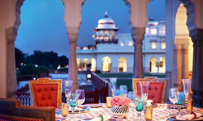 A dinner table set overlooking a palace.
