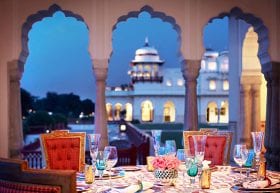 A dinner table set overlooking a palace.