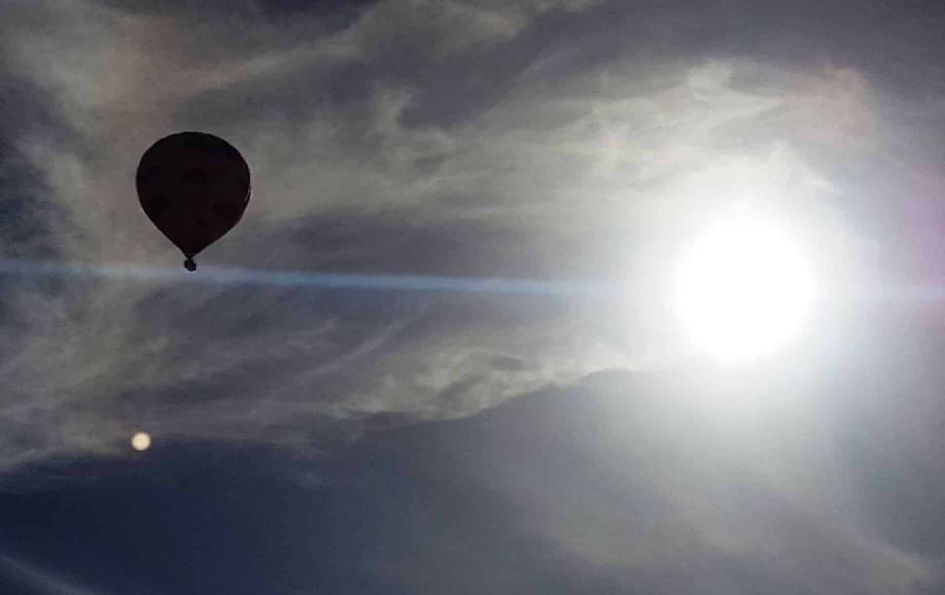 A hot air balloon being shadowed by the sun