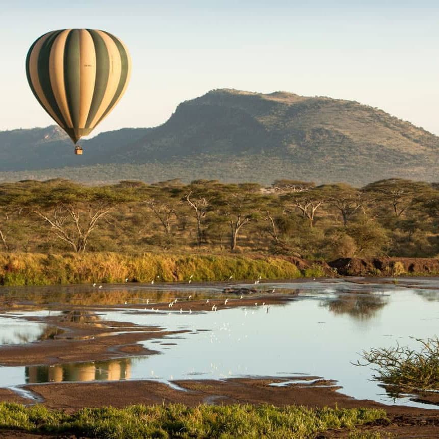 a hot air balloon flying over the Serengeti